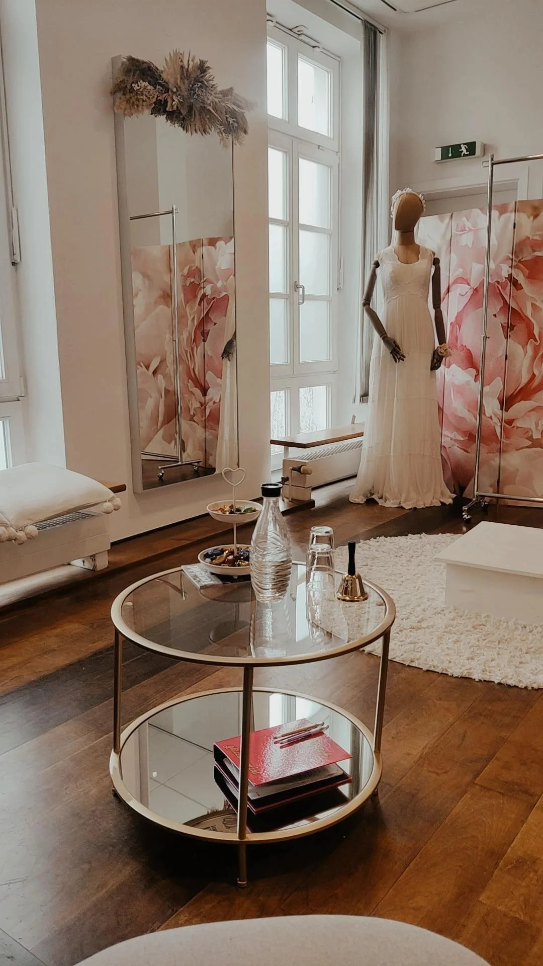 Ein elegantes Brautmodenstudio mit einem auf einem Ständer präsentierten Brautkleid und einem stilvollen Tisch. Der Raum strahlt eine entspannte Atmosphäre aus.