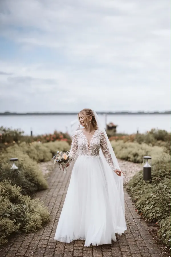 Brautkleid: Tiefer Ausschnitt, fließender Tüll – Glücksmoment Brautmode Oldenburg